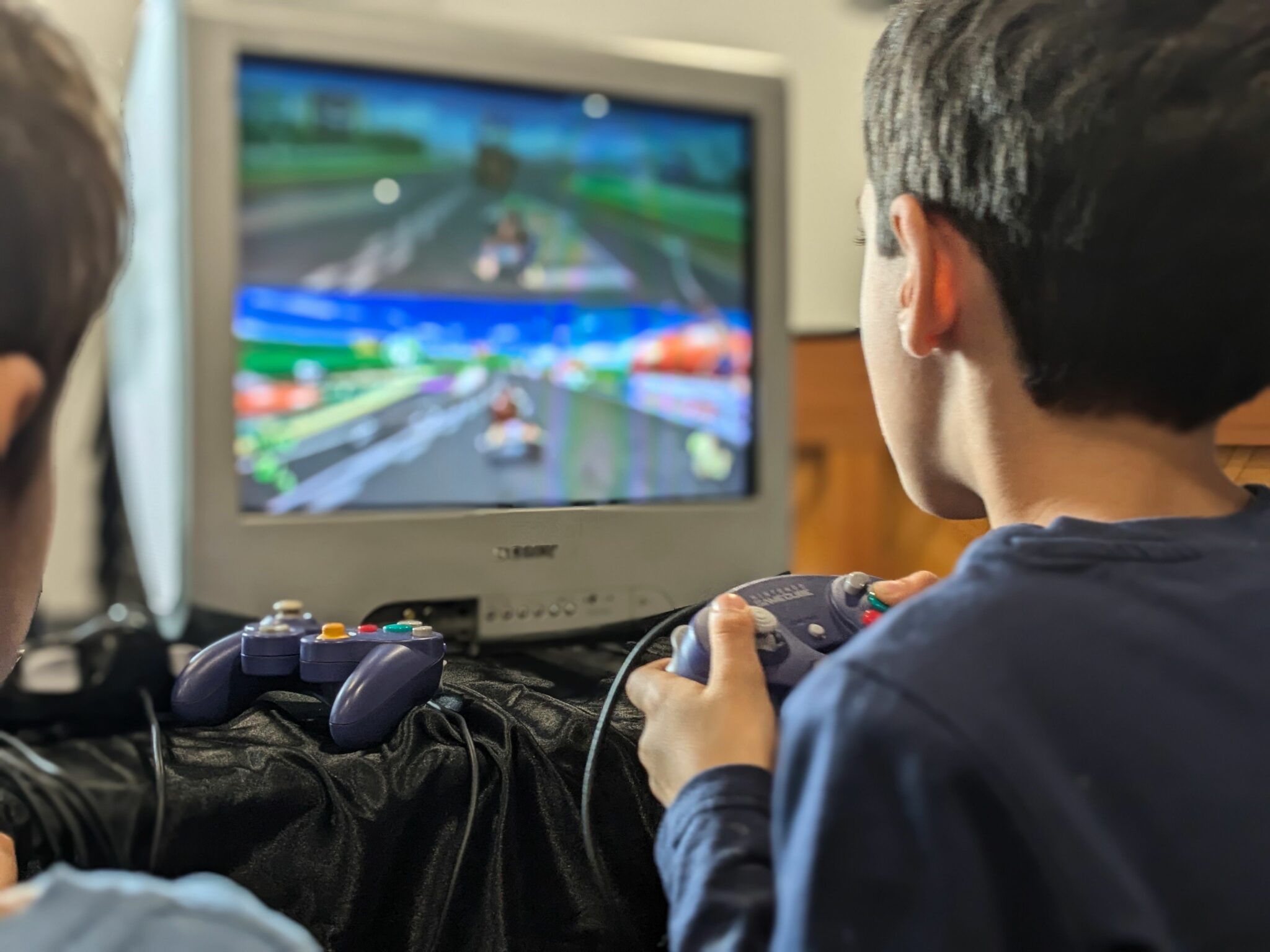 Un enfant jouant à Mario Kart avec ses copains